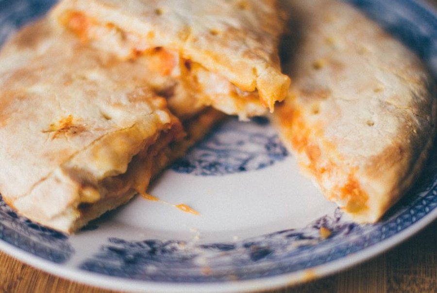 Une calzone coupée en deux sur une assiette à motifs bleus